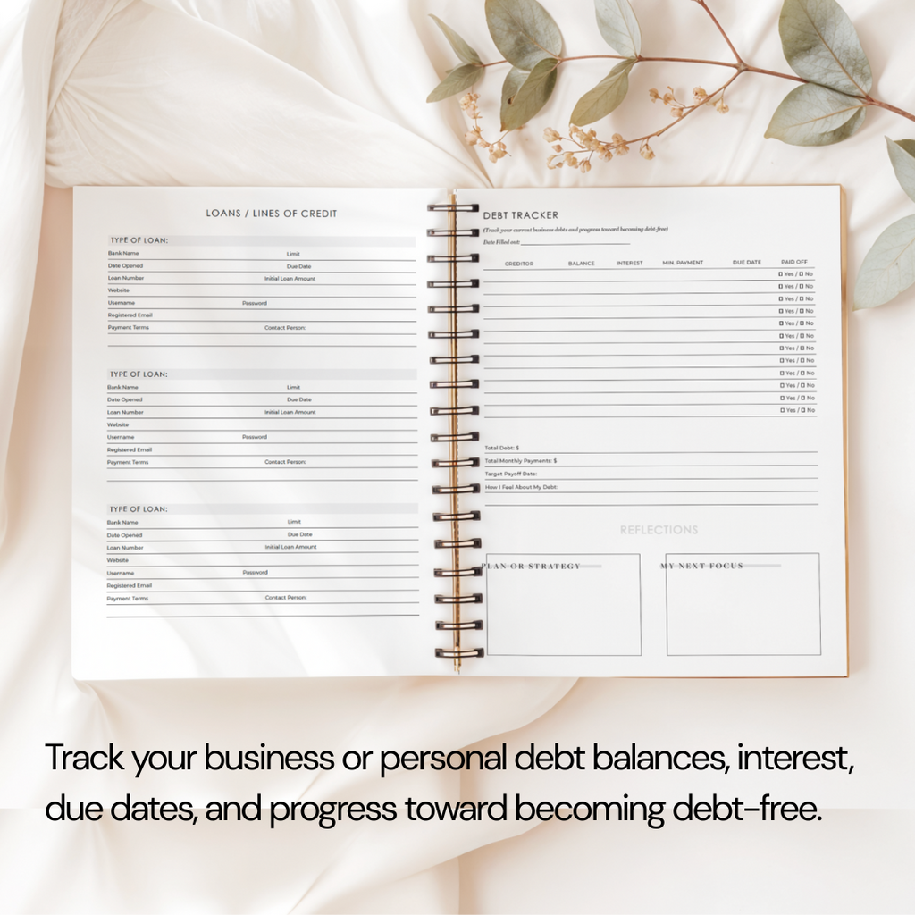 Open spiral-bound notebook with debt tracking pages on a soft beige background with eucalyptus leaves.